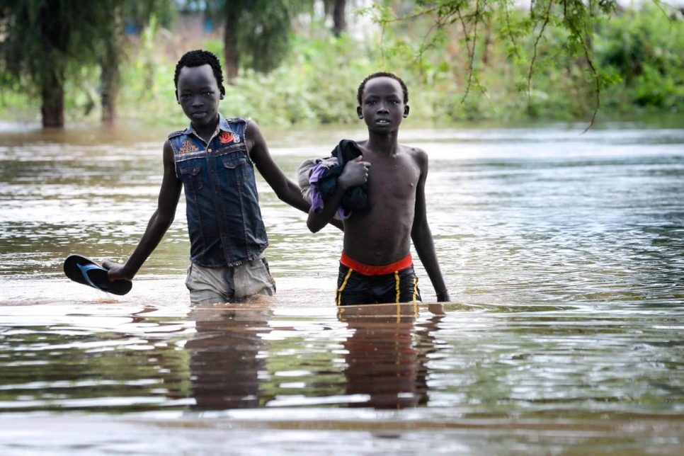 Two boys pick their way along a flooded road in Maban county, South Sudan.