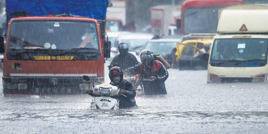 Vehicles make their way through a waterlogged road during heavy rain, at Kings Circle, in Mumbai.