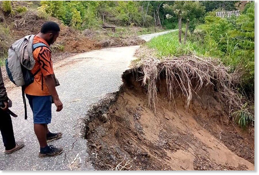 Local residents see a road damaged by landslides near Gumine Station, in the Chimbu region, Papua New Guinea.