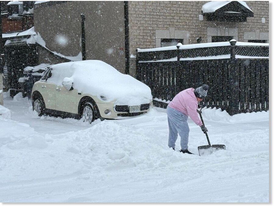 Click to enlarge A person clearing snow on a side street near Lansdowne Avenue and Dupont Street.