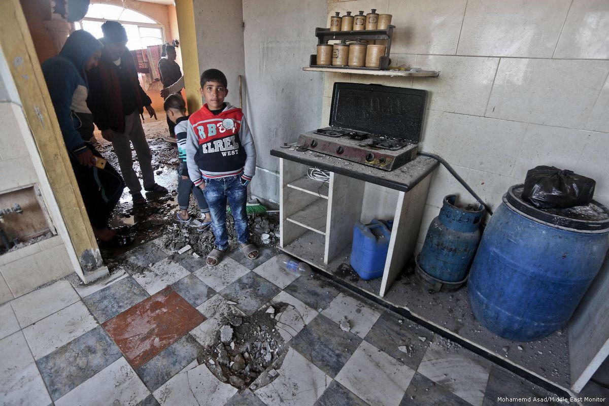 Gazans look at the damage done to their home after Israel carried out a missile attack in Gaza