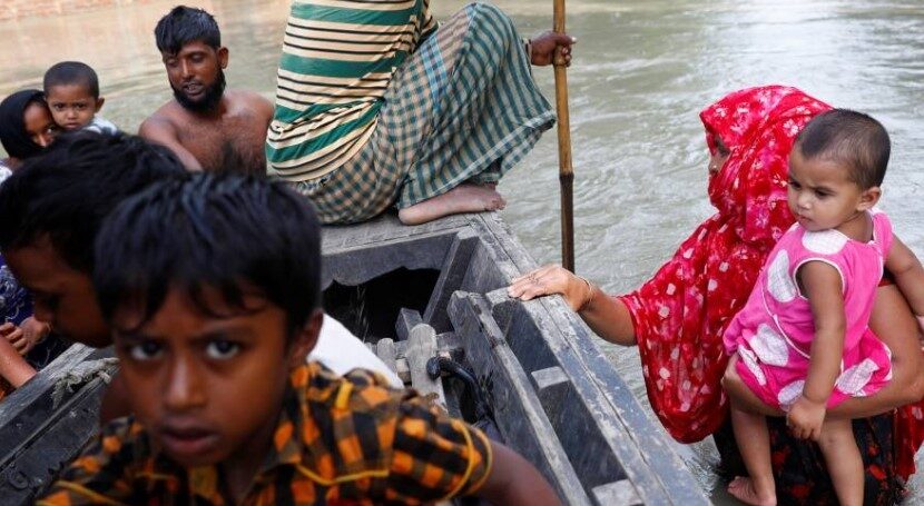Flood-affected people get on a boat