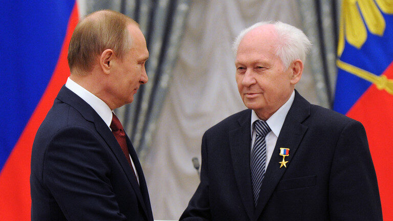 Russian President Vladimir Putin (L) awards Hero of Labour medal to Pavel Kamnev.