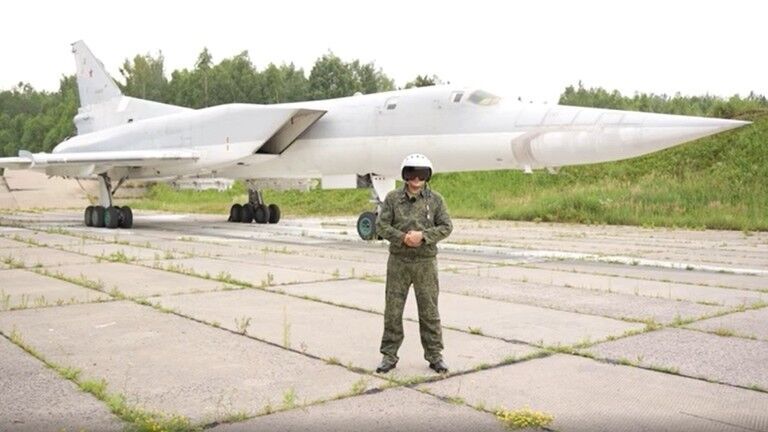 A Russian pilot standing in front of a Tu-22M3 strategic bomber