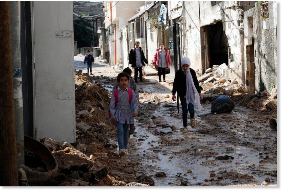 Palestinians children walk through the damaged streets of Tulkarem